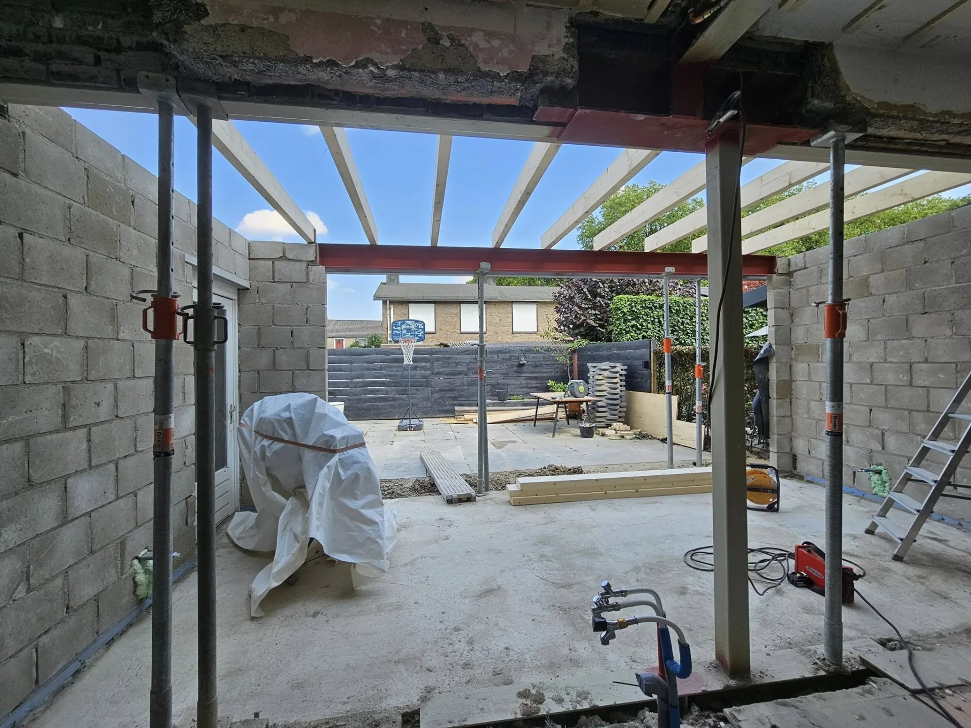 Uitbouw in aanbouw met stalen ligger, stempels en nieuwe dakbalken
